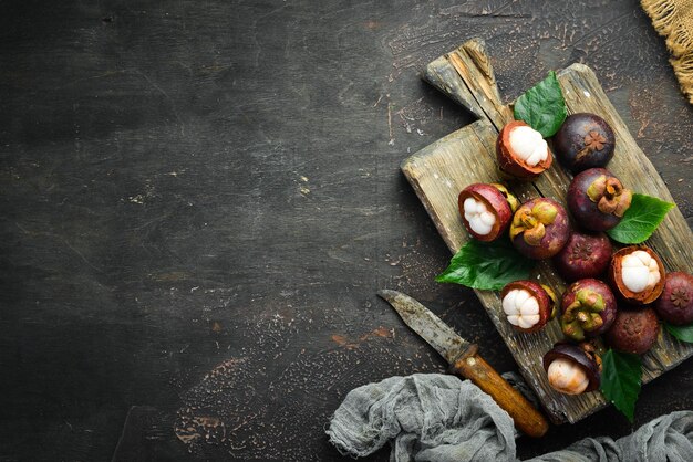 Tropische vruchten Mangosteen op een houten achtergrond Bovenaanzicht Vrije ruimte voor tekst