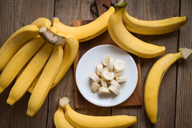 Tros bananen banaan gesneden op houten achtergrond rijp bananenschil fruit op vloer bovenaanzicht