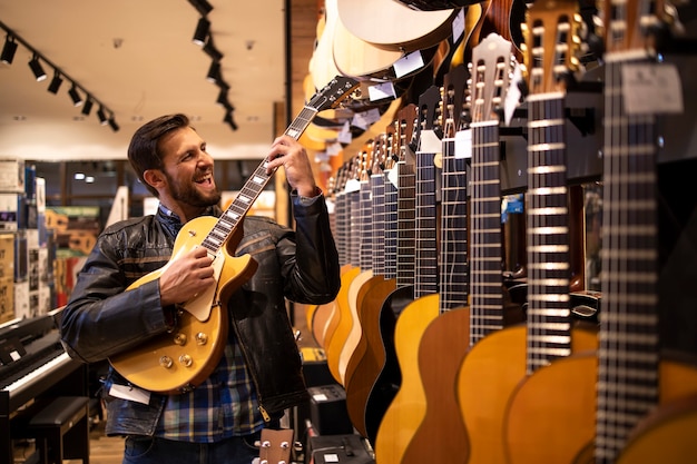 Foto trotse jonge rocker-muzikant in leer jacked elektrische gitaar spelen in muziekwinkel.