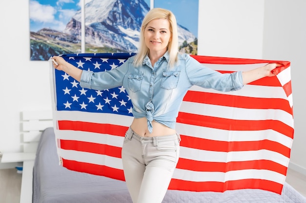 Trotse vrouw met de Amerikaanse vlag en glimlachen.