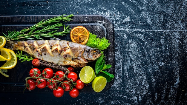 Trout fish baked with aromatic herbs and spices On Wooden background