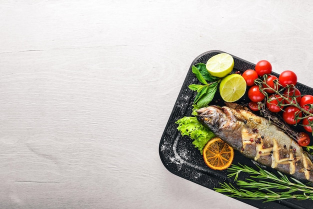 Trout fish baked with aromatic herbs and spices On Wooden background