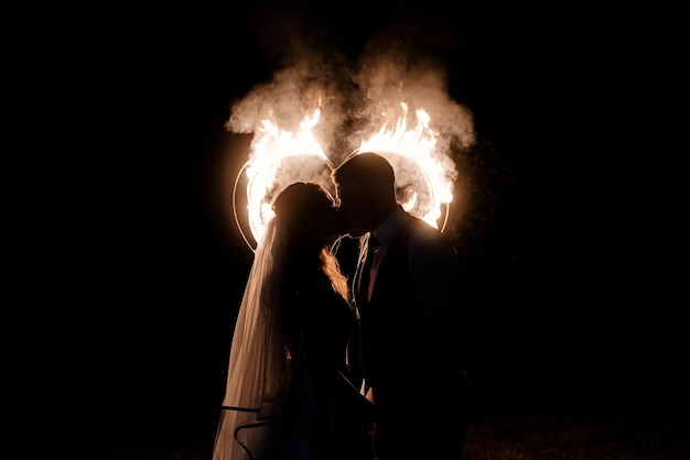 Trouwdag van de bruid en bruidegom nachtgeloften in de buurt van de boog met lichten op de achtergrond van vuurwerk