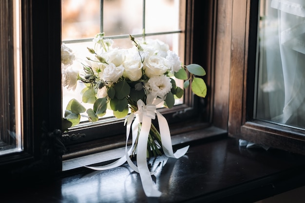 Trouwen boeket met pioenrozen en rozen op een stoel en corsages