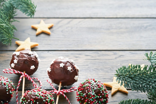 Trouwen Kerstmis zoete cake pops Kerstdessert ronde brownie cake pops met sterren topping op donkere groene achtergrond Kerst eten dessert concept en scène breedbeeld vakantie grens Bovenaanzicht