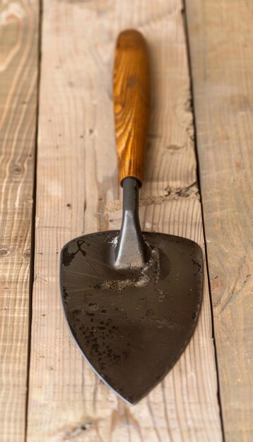 Photo a trowe with a wooden handle on a wooden surf