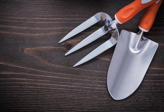 Trowel gardening fork and hand shovel on vintage wooden board agriculture concept