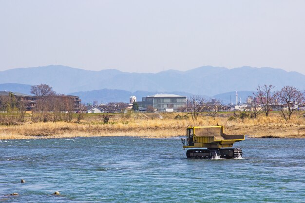 Truck and Dredging stone in river Katsura for to make water flow