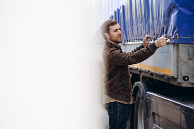 Truck driver standing by his lorry