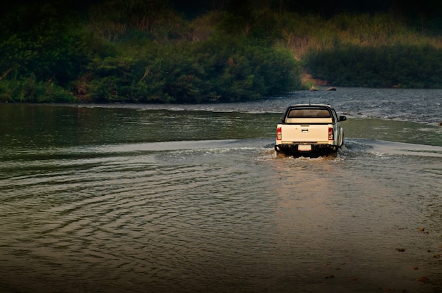 Photo the truck on the river in the forest