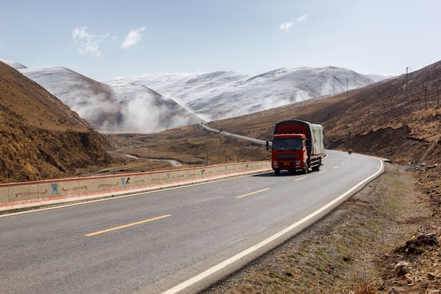 Truck on the road, Beautiful winter road in Tibet under snow mountain Sichuan China