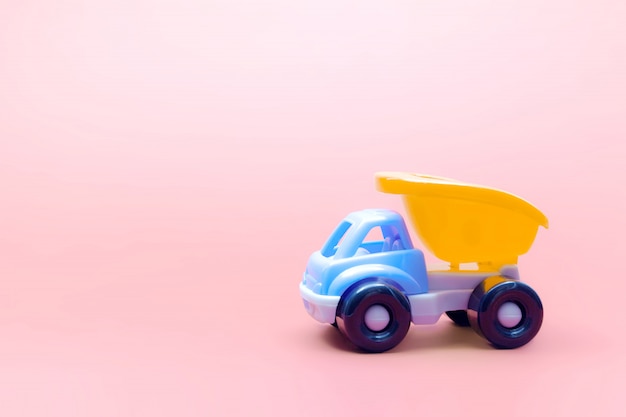 Truck toy model car on pink background, space for text