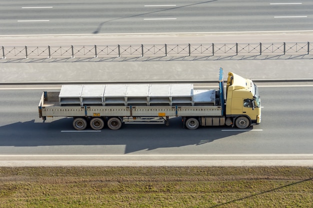 Photo truck with a fully loaded concrete block driving on the highway.