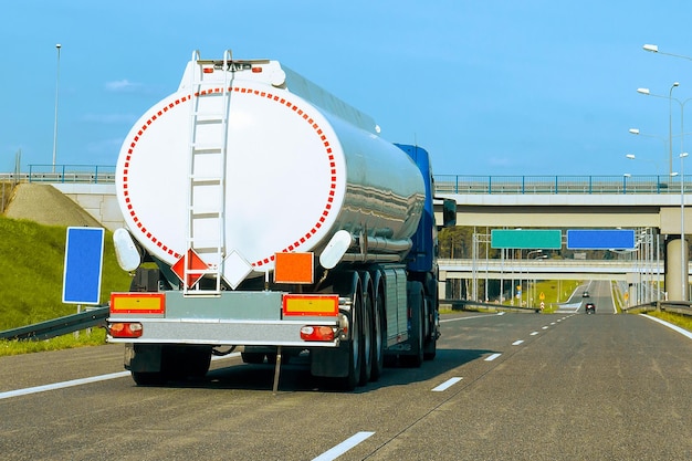 Truck with liquid or oil storage in road or highway of Poland. Lorry with service tanker cistern at logistics work. Semi trailer tank. Cargo car drive. Freight delivery. Transport export industry