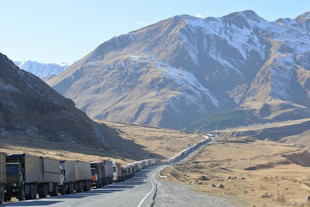 Trucks on road leading towards mountain during winter