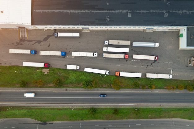 Foto camion in attesa di essere caricati nella vista dall'alto del centro logistico.