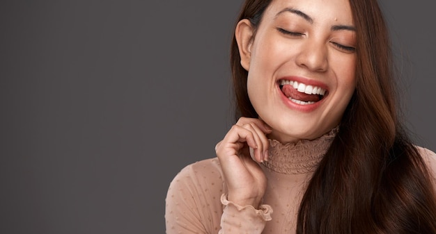 Photo true beauty comes from being yourself cropped shot of an attractive young woman making a face in studio against a grey background