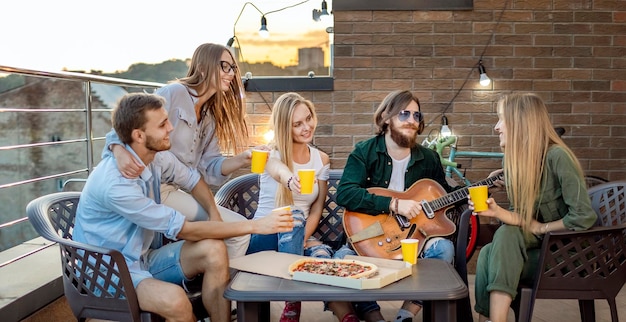 Veri amici che bevono birra e pizza