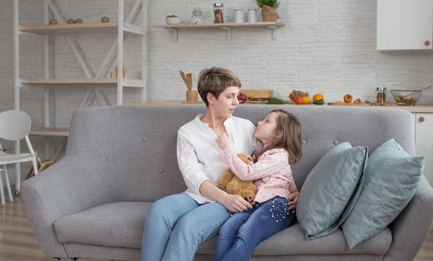 The true love of a mother and daughter A sensual portrait of a sweet happy mother and daughter gently embracing on the couch at home and smiling