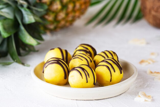 Truffles with mango and pineapple on a light table.