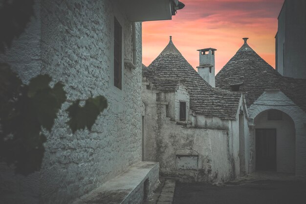 사진 bari italy 지평선에 일몰이 있는 alberobello의 trulli