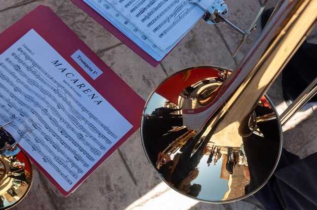 A trumpet next to the sheet music of the famous song La Macarena