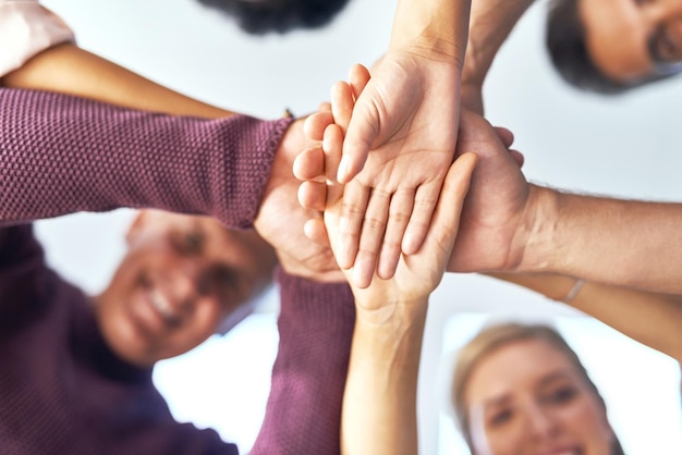 Trust is essential for building strong teams Cropped shot of a team of colleagues joining their hands in solidarity