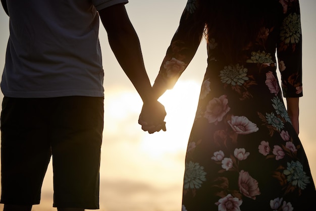 日没の結婚のコミットメントと団結をサポートするために手をつないでいる愛とカップルを信頼する男女と人々が連帯して敬意を表し、共感し、バレンタインデーにシルエットで希望を気遣う
