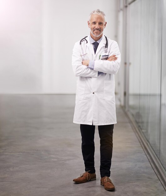 Trust me with your health Full length portrait of a mature doctor standing with his arms folded in the hospital corridor