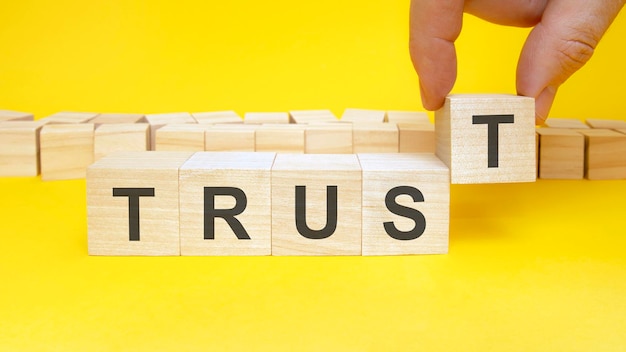 Trust symbol businessman turns wooden cubes the words renew beautiful yellow background copy space business concept