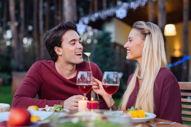 Try dear. Happy beautiful woman smiling while feeding her boyfriend