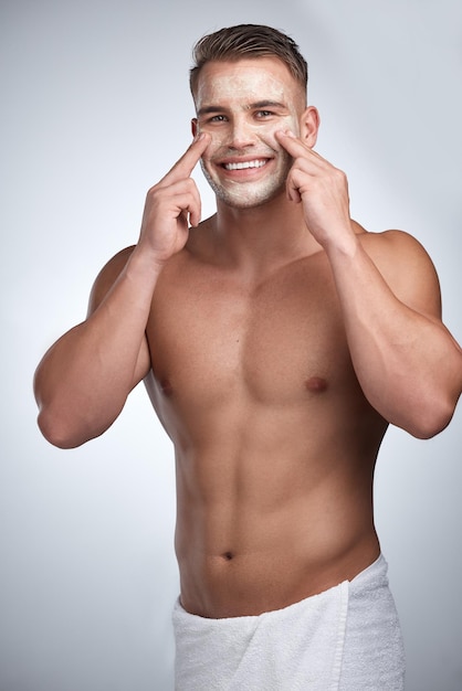 Trying to find my place Studio portrait of an attractive young man applying a beauty treatment to his face against a grey background