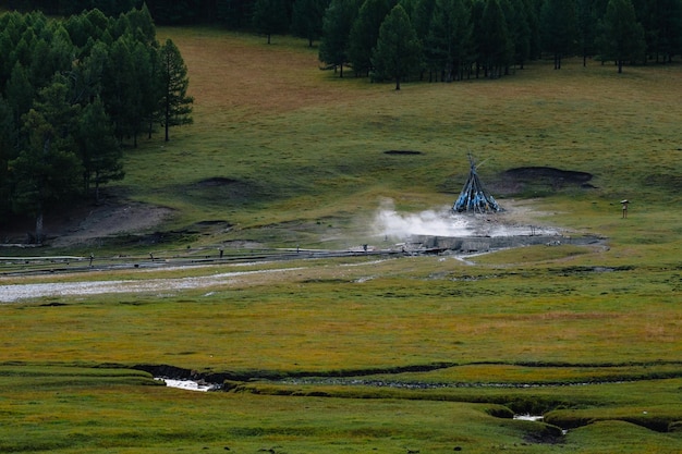 Tsenkher warmwaterbronnen markeerden een ovoo, met rook, vroeg in de ochtend in Mongolië