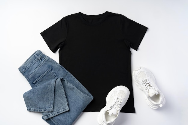 Tshirt jeans and white sneakers on gray background top view