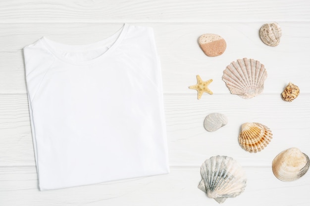 Макет футболки плоской планировки Морские раковины на белом деревянном фоне