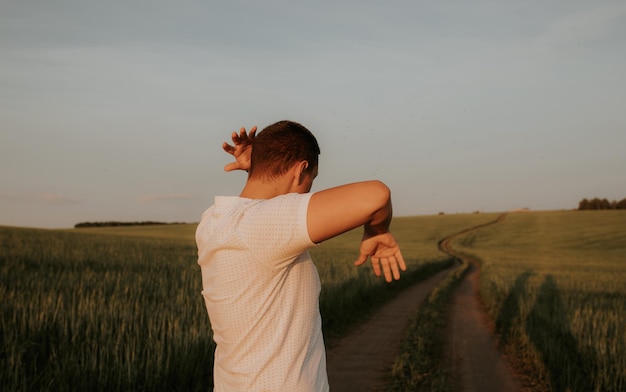 Photo tshirt shrugs off a swarm of insects while standing on a field road in a green field