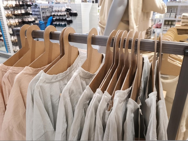 티셔츠는 트렌디한 파스텔 톤의 캐주얼 의류 매장 선반에 있는 친환경 판지 종이 옷걸이에 걸려 있습니다.