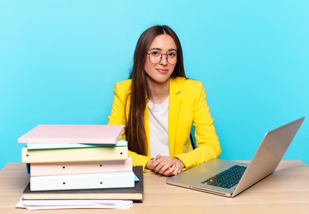 Tty businesswoman sitting on her desk working with a laptop