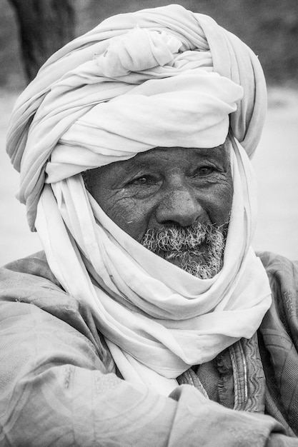 Tuareg man lies on the sand in Sahara desert, Hoggar mountains, Djanet, Algeria