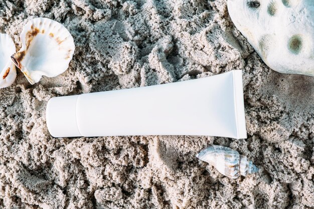 Photo the tube of cream lies on the sand sun protection skin hydration cosmetic mock-up