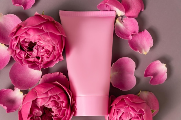 옅은 분홍색 배경에 분홍색 장미가 있는 크림 또는 로션 튜브 유기농 에코 화장품 트리트먼트 스파 뷰티 스킨케어 및 건강 관리 브랜드 광고