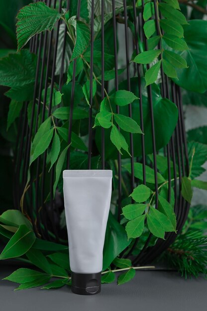 tube for cream stands near green foliage