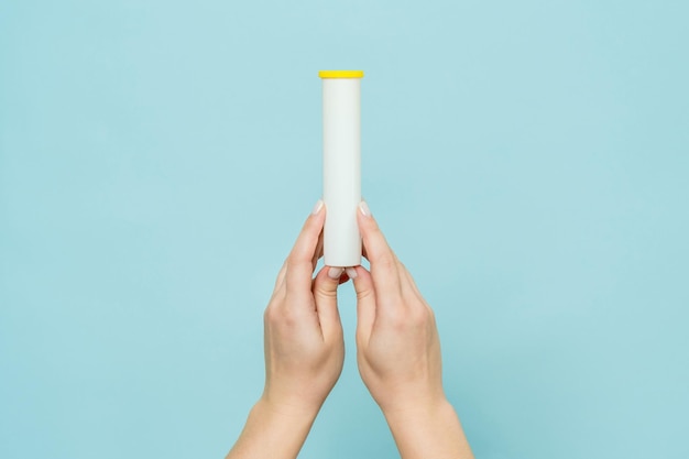 Tube for vitamins pills in a hand Packaging Mockup