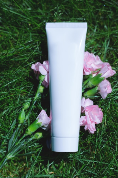 tube of white cream on a background of green plants