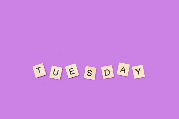 Tuesday write with wooden letter cubes on a purple background