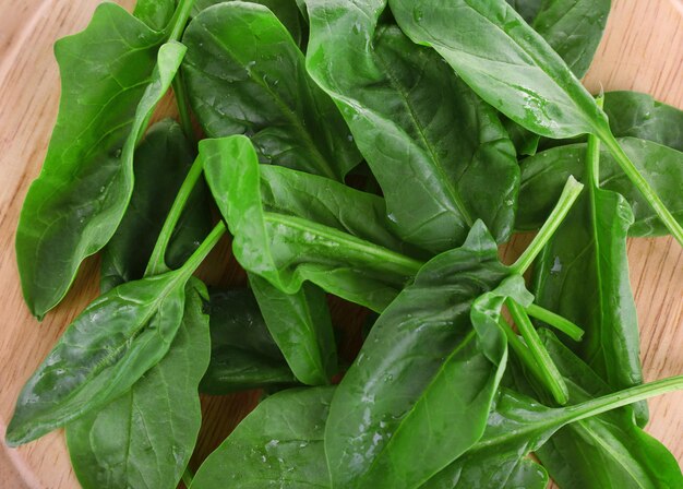 Photo tuft of fresh sorrel on wooden cutting board isolated on white