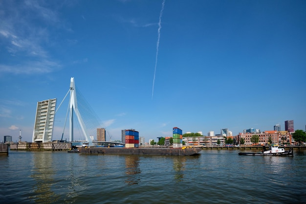 Tug boat towing barge with containers under open bascule part of Erasmusbrug bridge