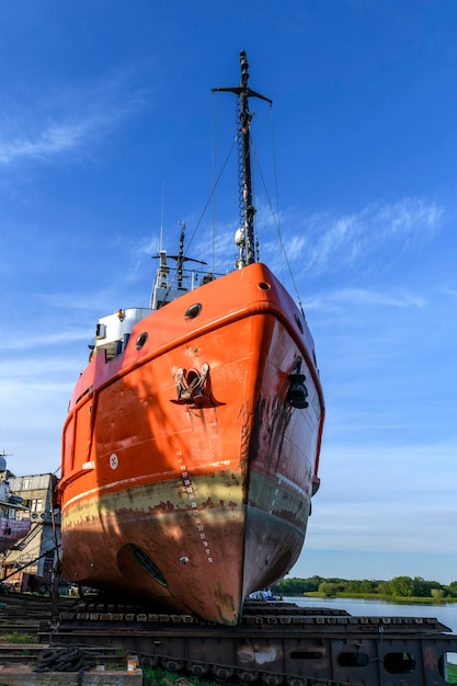 Tug vessel ashore on ship repairing yard