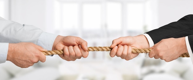 Photo tug war two businessman pulling a rope