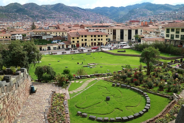 Tuin buiten Coricancha-tempel in Cusco van Peru, met het symbool van Inca-mythologie van Condor